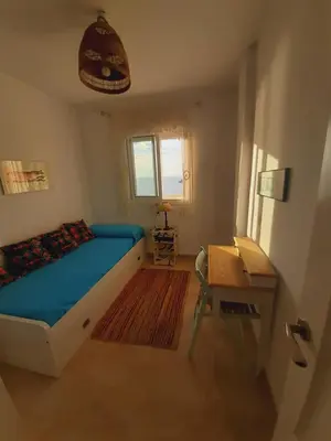 a bedroom with a bed and a desk and a window at Balcón al Mar in Rota