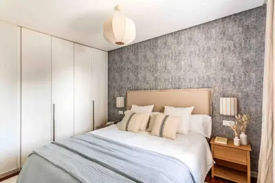 a bedroom with a bed and a gray wall at A paradise with ocean views in Conil de la Frontera