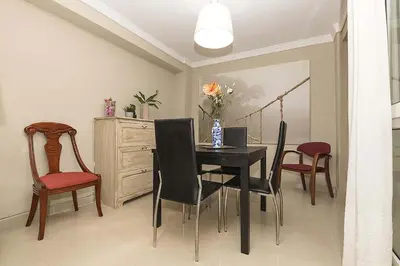 a dining room with a black table and chairs at Victoriamar in Cádiz