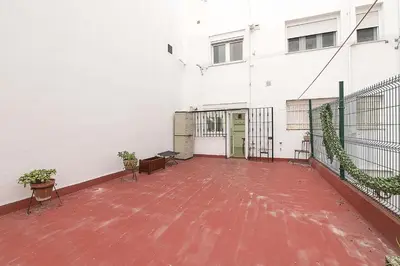 an empty courtyard of a white building with plants at Victoriamar in Cádiz