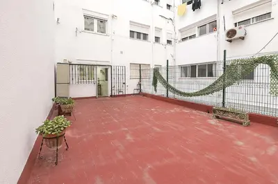 an empty courtyard of a white building with plants at Victoriamar in Cádiz