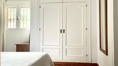 a white closet with two doors in a bedroom at Avenida de los Pescadores in Novo Sancti Petri