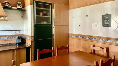 a kitchen with a table and a green refrigerator at Avenida de los Pescadores in Novo Sancti Petri
