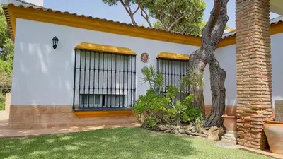 a house with two windows and a grass yard at Avenida de los Pescadores in Novo Sancti Petri