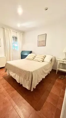 a bedroom with a large bed with a white bedspread at Avenida de los Pescadores in Novo Sancti Petri