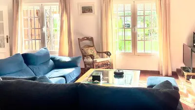 a living room with a blue couch and a table at Avenida de los Pescadores in Novo Sancti Petri
