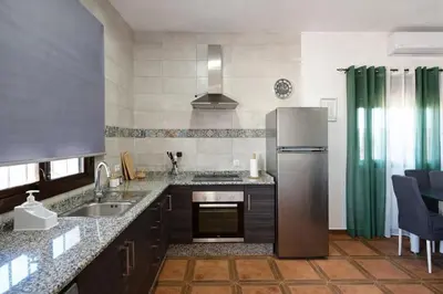 a kitchen with a refrigerator and a sink at Chalet Amanecer in Conil de la Frontera