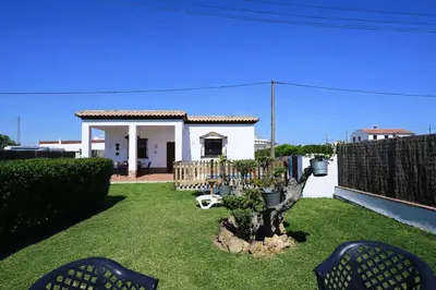 a yard with a small house with a fence at Chalet Atardecer in Conil de la Frontera