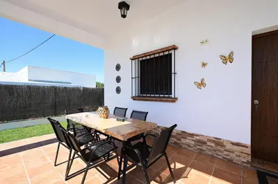 a dining room with a wooden table and chairs at Chalet Atardecer in Conil de la Frontera