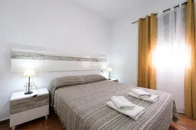 a bedroom with a bed with two towels on it at Chalet Atardecer in Conil de la Frontera