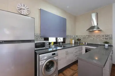a kitchen with a refrigerator and a washing machine at Chalet Atardecer in Conil de la Frontera