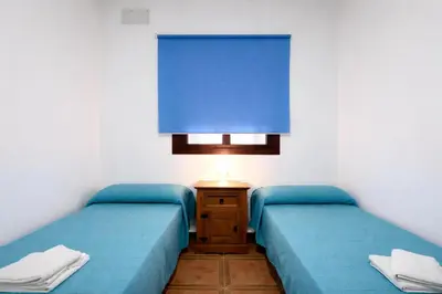 two beds in a room with blue sheets at Chalet Atardecer in Conil de la Frontera