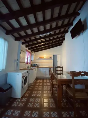 a kitchen with a table and a washing machine at Large historic house in the center of Barrio Alto in Sanlúcar de Barrameda