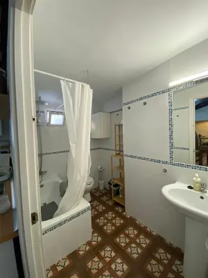 a bathroom with a tub and a toilet and a sink at Large historic house in the center of Barrio Alto in Sanlúcar de Barrameda
