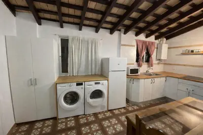 a kitchen with a washing machine and a refrigerator at Large historic house in the center of Barrio Alto in Sanlúcar de Barrameda