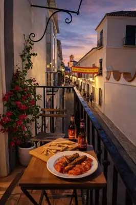 a plate of food on a table on a balcony at Large historic house in the center of Barrio Alto in Sanlúcar de Barrameda
