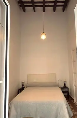 a bedroom with a bed in a white room at Large historic house in the center of Barrio Alto in Sanlúcar de Barrameda