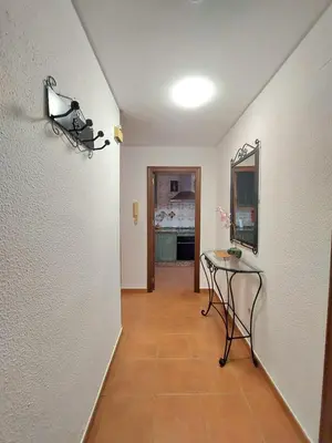a hallway with a table and a mirror on a wall at Adelitas Home El Puerto in El Puerto de Santa María