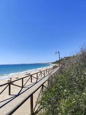 a wooden boardwalk leading down to the beach at Adelitas Home El Puerto in El Puerto de Santa María