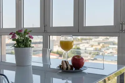 a glass of wine and an apple on a table at Ático Avda Cádiz Playa in Cádiz