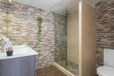 a bathroom with a sink and a glass shower at Ático Avda Cádiz Playa in Cádiz