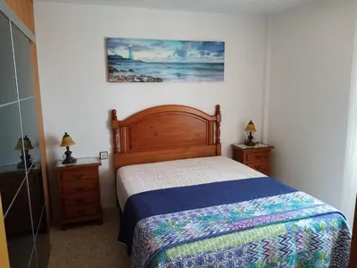 a bedroom with a bed and a painting on the wall at La Barrosa beach Chiclana in Novo Sancti Petri