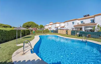 a swimming pool in a yard next to some houses at Nice Home In Chiclana De La Fronter in Novo Sancti Petri