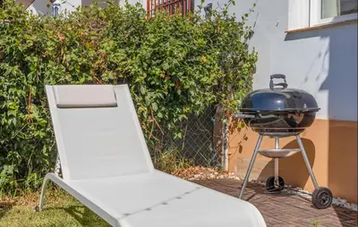 a grill sitting next to a bbq grill at Nice Home In Chiclana De La Fronter in Novo Sancti Petri
