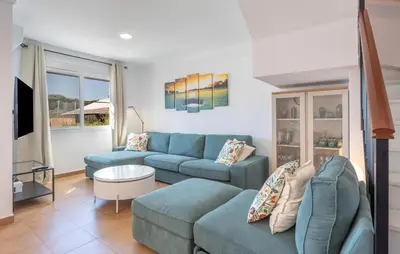 a living room with a blue couch and a table at Nice Home In Chiclana De La Fronter in Novo Sancti Petri