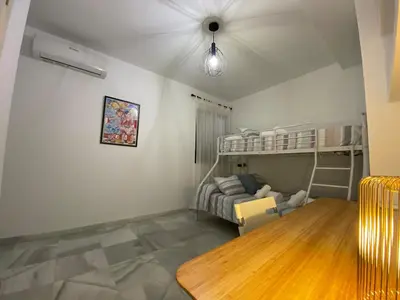 a bedroom with a bunk bed and a table at Dúplex Casco Histórico, terraza, garaje in Sanlúcar de Barrameda