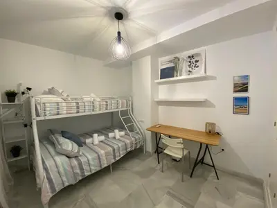 a room with two bunk beds and a couch at Dúplex Casco Histórico, terraza, garaje in Sanlúcar de Barrameda