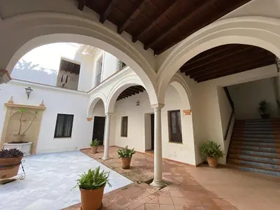 a building with a large wooden door on a street at Dúplex Casco Histórico, terraza, garaje in Sanlúcar de Barrameda