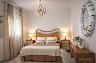 a bedroom with a bed and a chandelier at Chalet con piscina en Naveros in Los Naveros