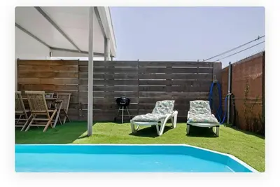a patio with two chairs and a swimming pool at Casa Dana in Cádiz
