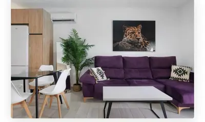 a living room with a purple couch and a picture of a tiger at Casa Dana in Cádiz