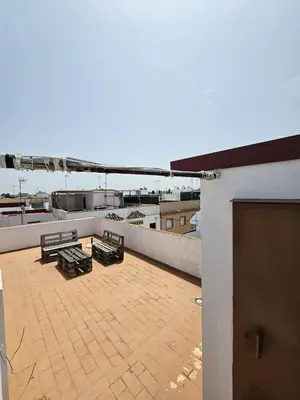 a patio with benches on the roof of a building at Apartamento Pepa in Chipiona