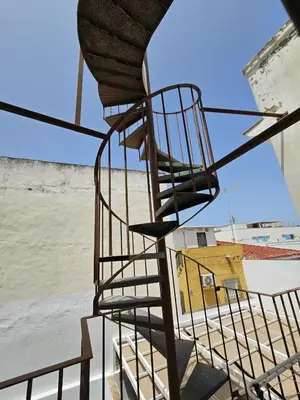 a metal spiral staircase on top of a building at Apartamento Pepa in Chipiona