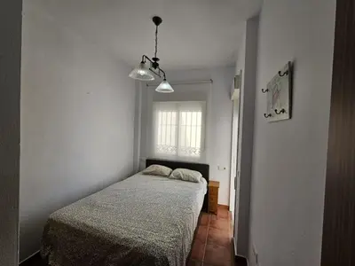 a small bedroom with a bed and a window at Apartamento Pepa in Chipiona