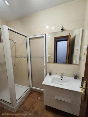 a bathroom with a shower and a sink and a mirror at Apartamento Pepa in Chipiona