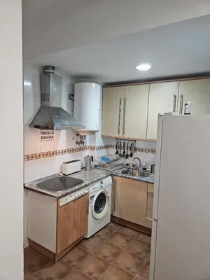 a kitchen with a washing machine and a refrigerator at Apartamento Pepa in Chipiona