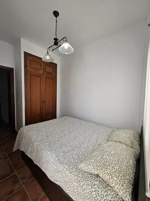a bedroom with a bed and two lights at Apartamento Pepa in Chipiona