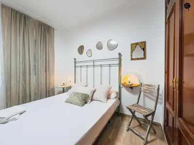 a bedroom with a white bed and a chair at La Caleta Prime Grupo AC Gestion in Cádiz