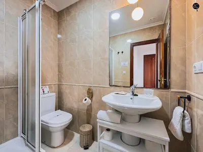 a bathroom with a sink and a toilet and a mirror at La Caleta Prime Grupo AC Gestion in Cádiz