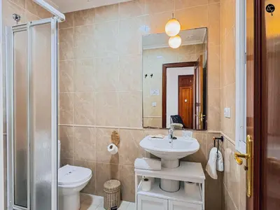 a bathroom with a sink and a toilet and a mirror at La Caleta Prime Grupo AC Gestion in Cádiz