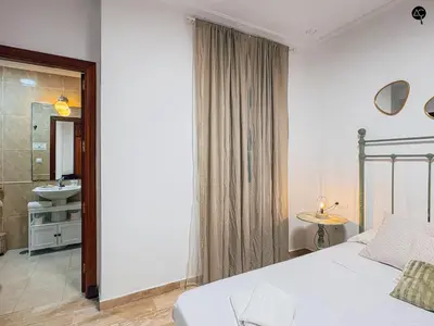 a bedroom with a bed and a bathroom with a sink at La Caleta Prime Grupo AC Gestion in Cádiz