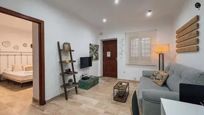 a living room with a blue couch and a television at La Caleta Prime Grupo AC Gestion in Cádiz