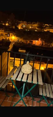 a hat sitting on top of a bench at night at Apartamentos ÁBREME Y VERÁS in Arcos de la Frontera