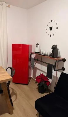 a red refrigerator in a room with a clock on the wall at Apartamentos ÁBREME Y VERÁS in Arcos de la Frontera