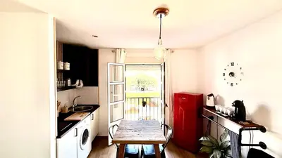 a small kitchen with a table and a red refrigerator at Apartamentos ÁBREME Y VERÁS in Arcos de la Frontera