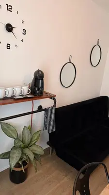 a living room with a black couch and clocks on the wall at Apartamentos ÁBREME Y VERÁS in Arcos de la Frontera